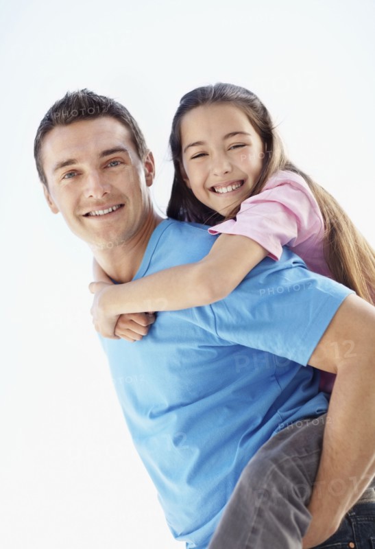 Father carrying daughter (10-11) on back. Photo : Momentimages