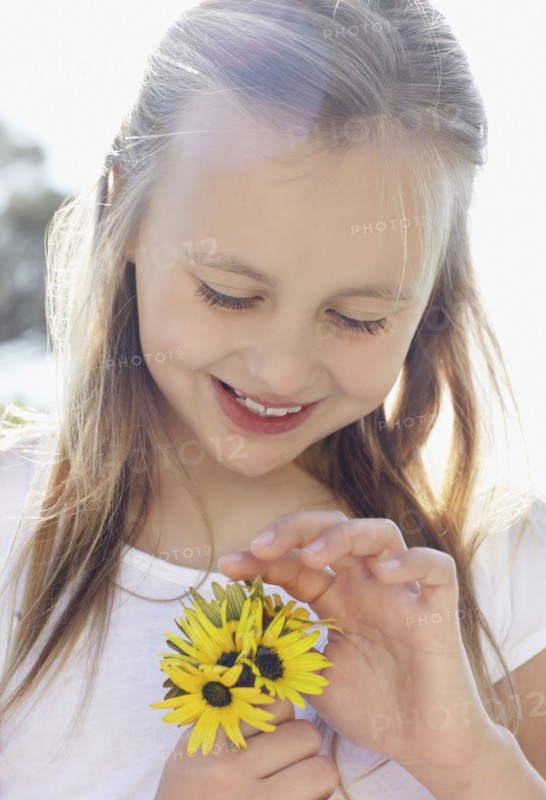 Girl (10-11) with sunflowers. Photo : Momentimages
