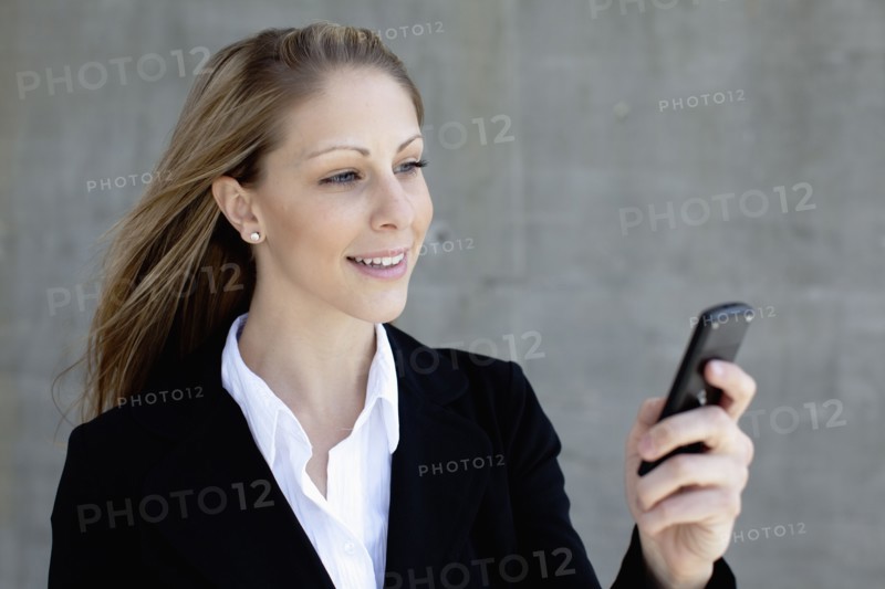 Businesswoman using mobile phone. Photo : Johannes Kroemer