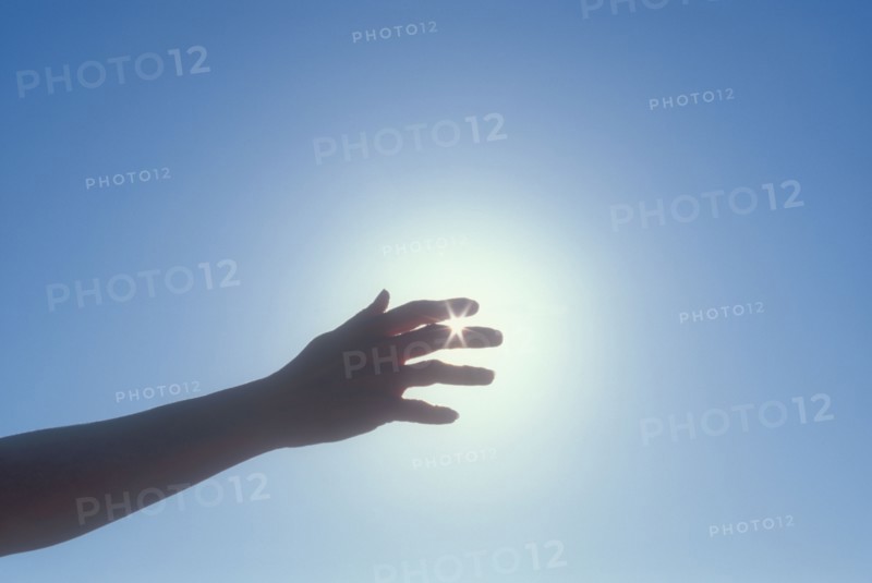 Silhouette of woman's hand against sky. Photo : Chris Hackett