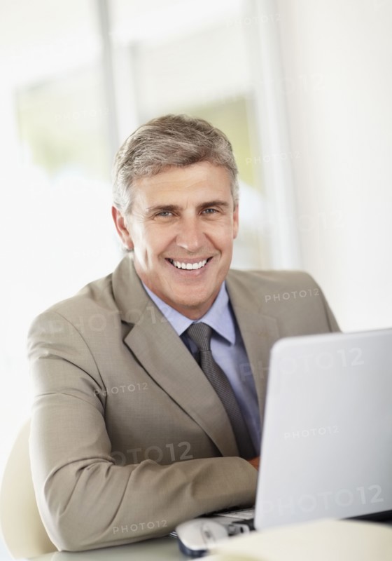 Portrait of businessman with laptop. Photo : Momentimages