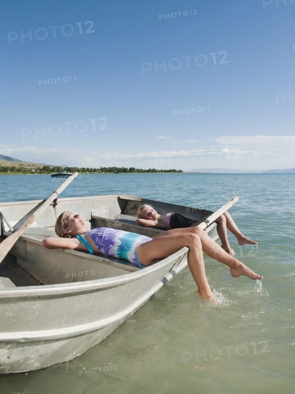 Girls (6-7,8-9) resting on boat.