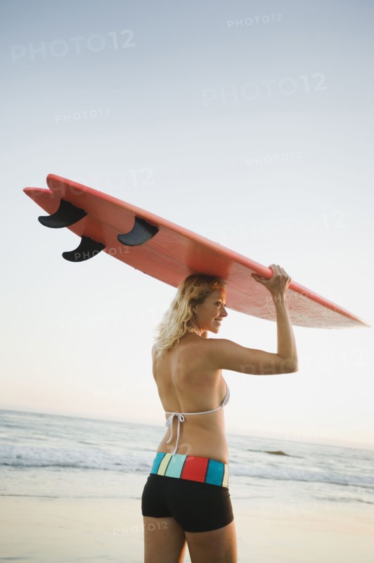Portrait of woman with surfboard.