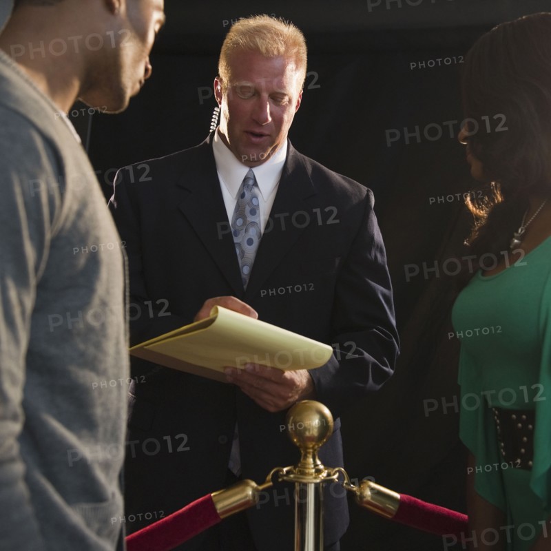 Bouncer checking invitation at red carpet event. Photo : Jamie Grill