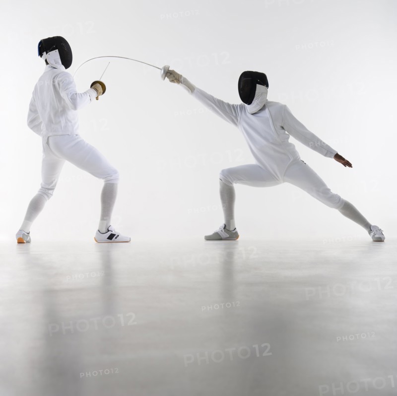 Studio shot of fencers in attacking lunge.