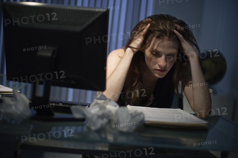 Exhausted woman working late in office.