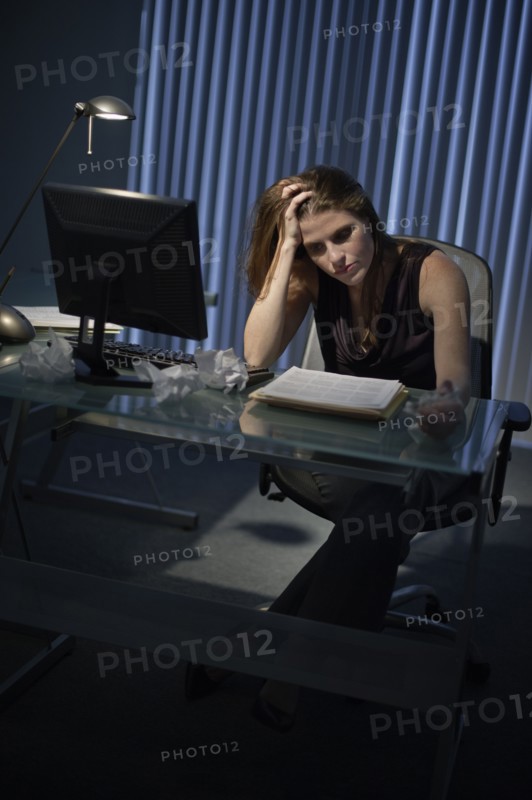 Exhausted woman working late in office.