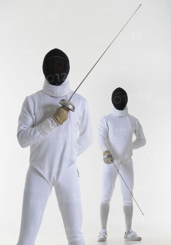 Studio portrait of fencer holding fencing foil.