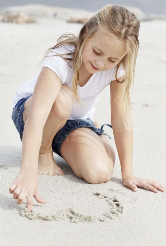 Girl (10-11) playing on beach. Photo : Momentimages