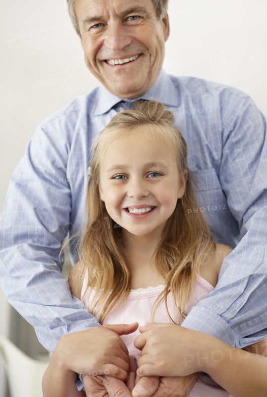 Portrait of smiling grandfather and granddaughter (10-11). Photo : Momentimages