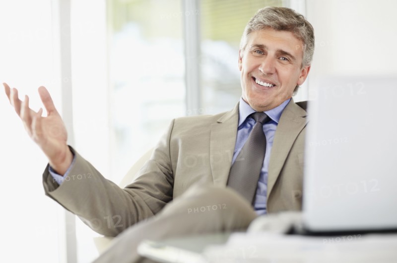 Portrait of cheerful businessman with laptop. Photo : Momentimages