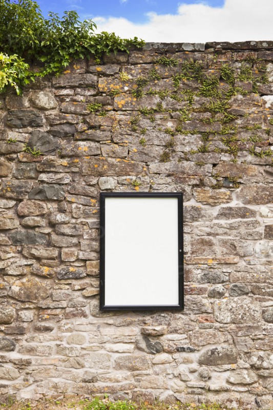 Blank sign on stone wall . Photo : Jon Boyes