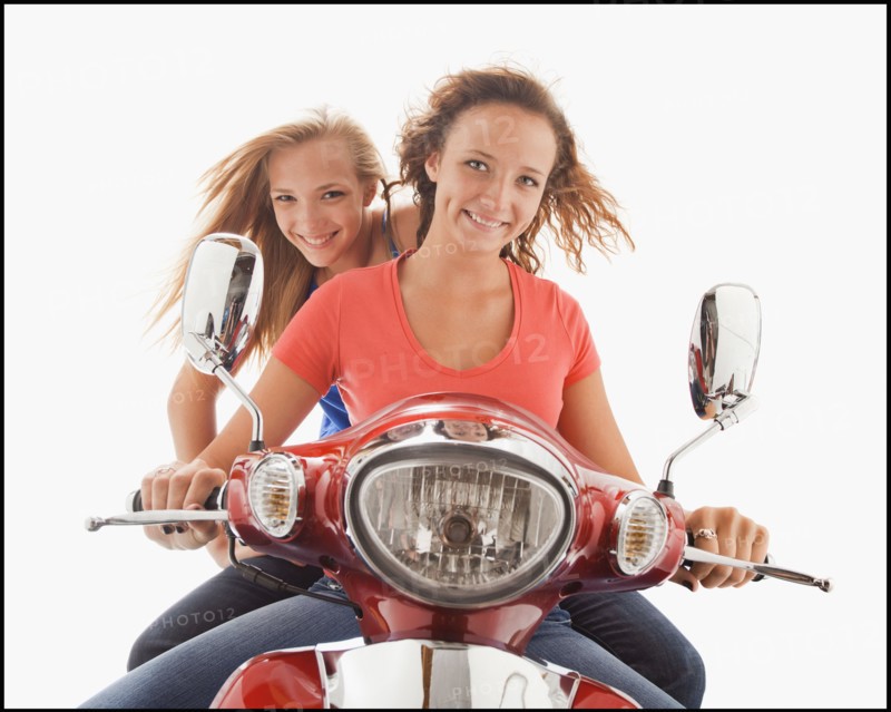 Young girls (16-17) riding scooter. Photo : Mike Kemp