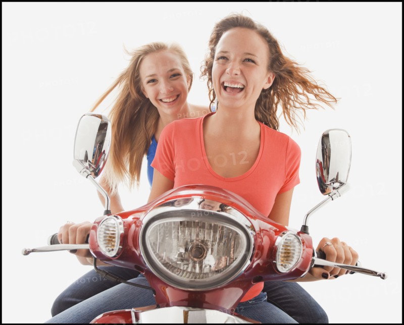 Young girls (16-17) riding scooter. Photo : Mike Kemp