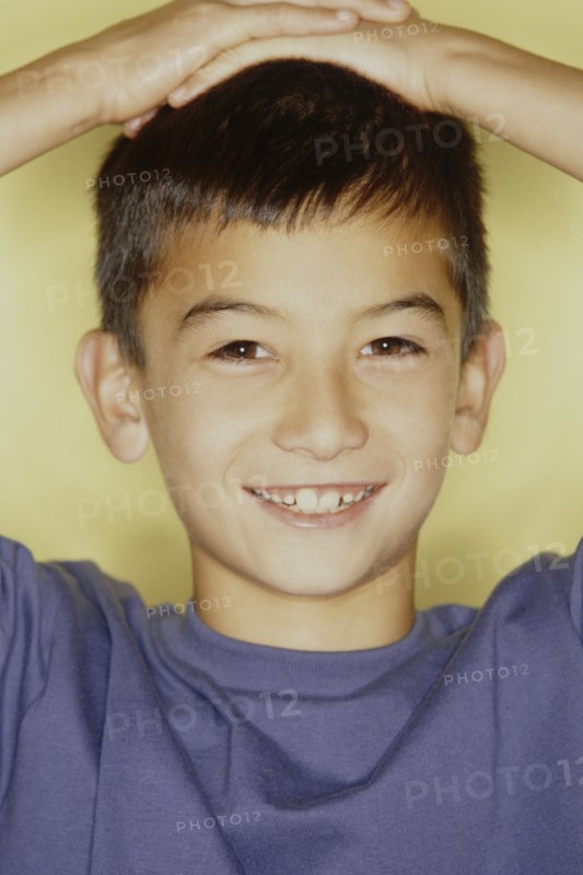 Cute young boy with his hands on his head. Photo : Fisher Litwin