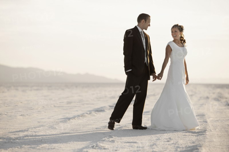 Bride and groom holding hands in desert. Photo : FBP