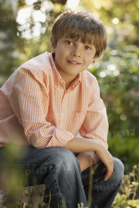 Portrait of boy (8-9) sitting in garden. Photo : FBP