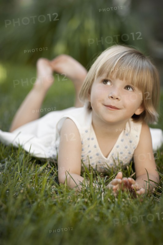 Girl (2-3) lying on grass. Photo : FBP
