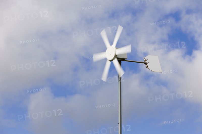 Old wind turbine against cloudy sky. Photo : Jon Boyes