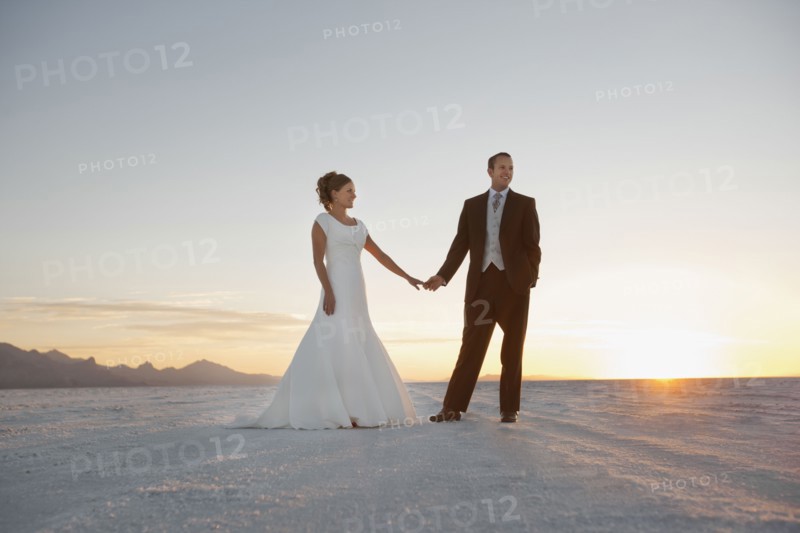 Bride and groom holding hands in desert. Photo : FBP