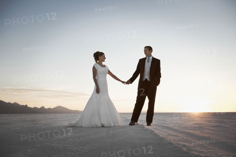Bride and groom holding hands in desert. Photo : FBP