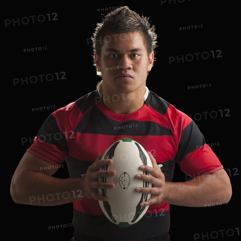 Studio portrait of male rugby player holding ball. Photo : Mike Kemp