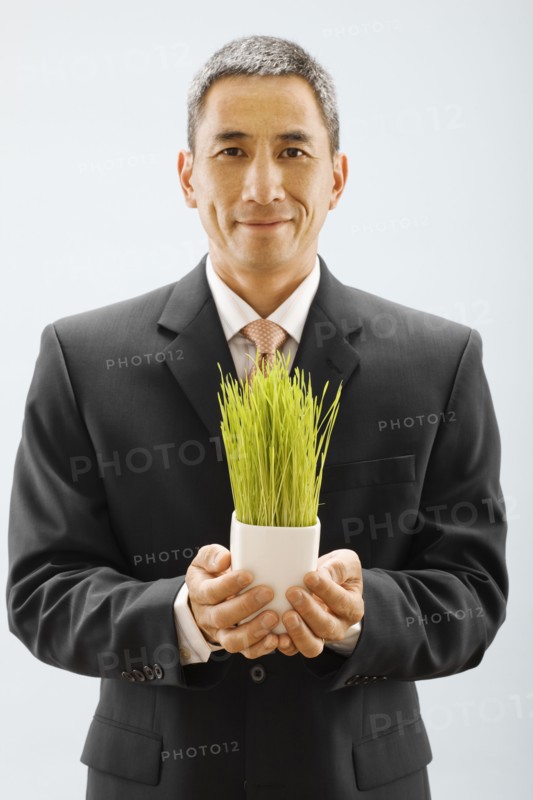 Studio portrait of young man holding wheat grass. Photo : FBP