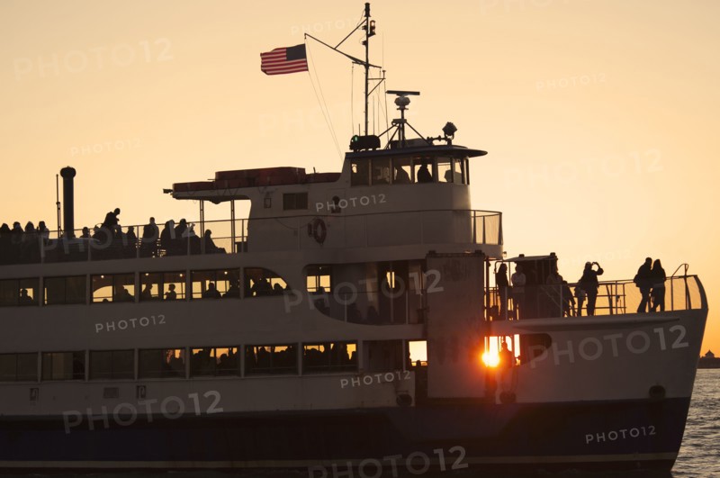 USA, New York City, Silhouette of passengers on tourboat.