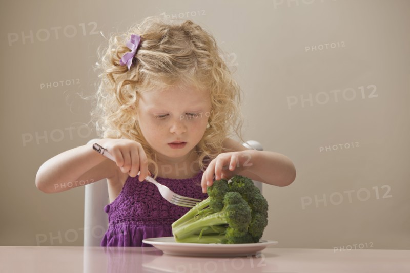 USA, Utah, Lehi, girl (2-3) eating broccoli. Photo : Mike Kemp
