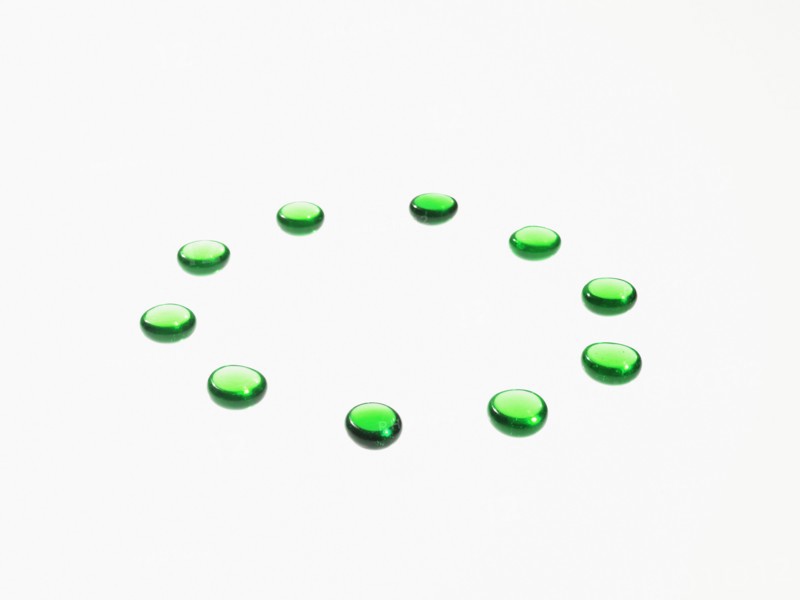 Studio shot of green glass beads in circle. Photo : David Arky