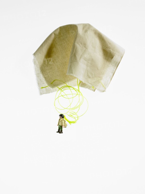 Studio shot of figurine with paper parachute. Photo : David Arky