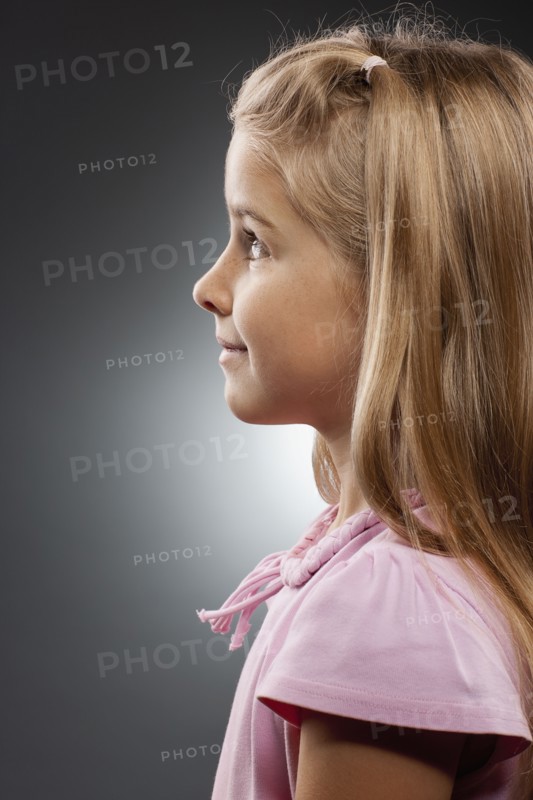 Girl (8-9) looking up, studio shot. Photo : FBP