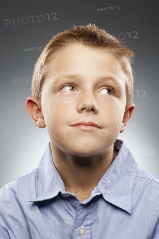 Portrait of boy (8-9) wearing shirt and looking away, studio shot. Photo : FBP