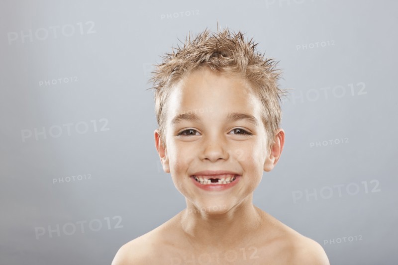 Studio portrait of toothless boy (8-9) smiling. Photo : FBP