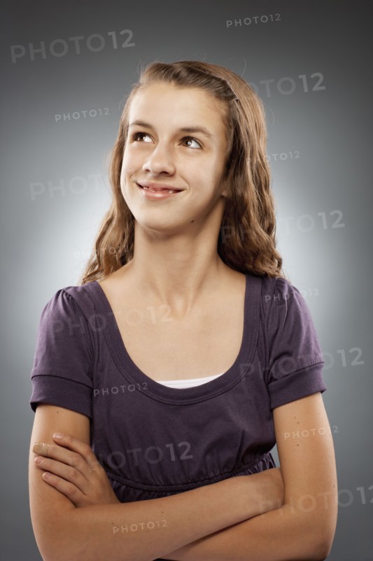 Portrait of girl (12-13) looking at camera with arms crossed, studio shot. Photo : FBP