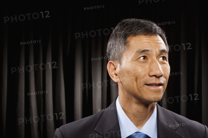USA, Utah, Provo, Businessman standing in front of black curtain. Photo : FBP