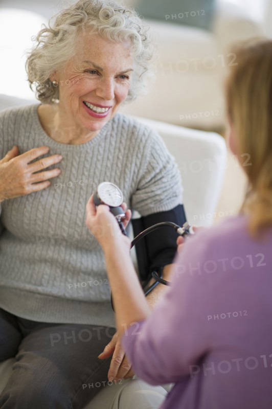 USA, New Jersey, Jersey City, Female nurse checking patients blood pressure.