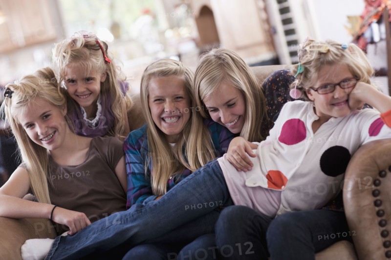 USA, Utah, family portrait of sisters on sofa (6-7, 8-9, 12-13, 14-15, 16-17). Photo : Tim Pannell