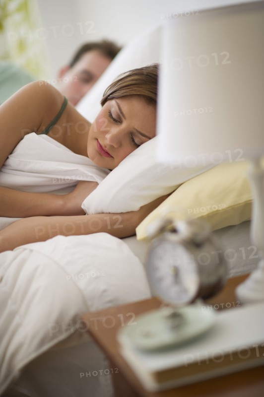 USA, New Jersey, Jersey City, Young couple sleeping in bed.