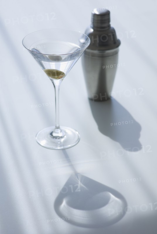 Cocktail shaker and cocktail in glass.