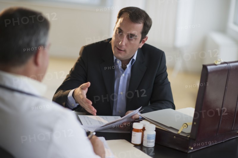 USA, New Jersey, Jersey City, Medical sales representative talking with doctor in office.