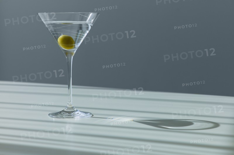 Cocktail with olive in glass.