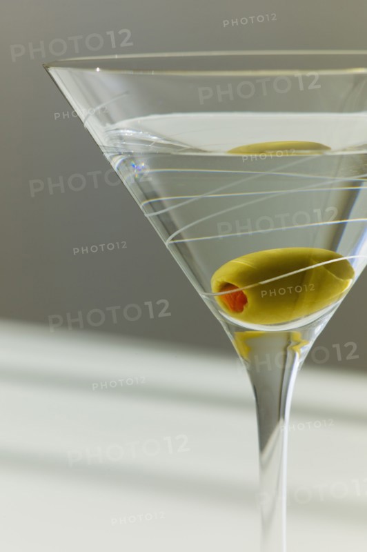 Cocktail with olive in glass.