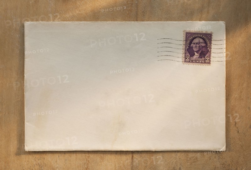 Blank envelope on wooden table.