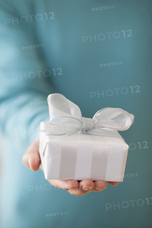 USA, New Jersey, Jersey City, Man holding gift box in front of him.