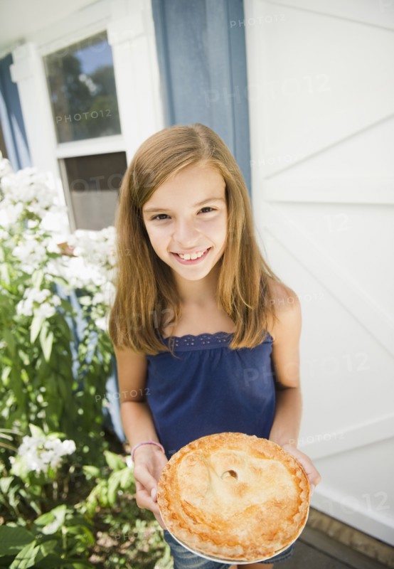 USA, New York, Girl (10-11) holding apple pie. Photo : Jamie Grill Photography