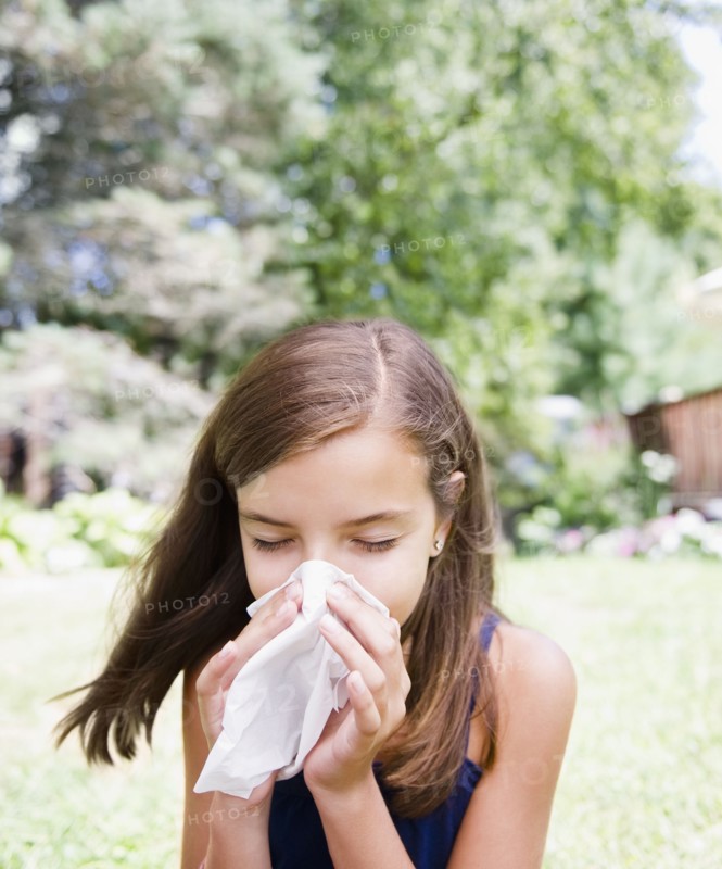 USA, New York, Girl (10-11) blowing nose. Photo : Jamie Grill Photography