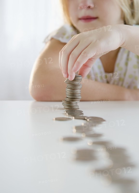 USA, New Jersey, Jersey City, Girl (8-9) playing with coins. Photo : Jamie Grill Photography