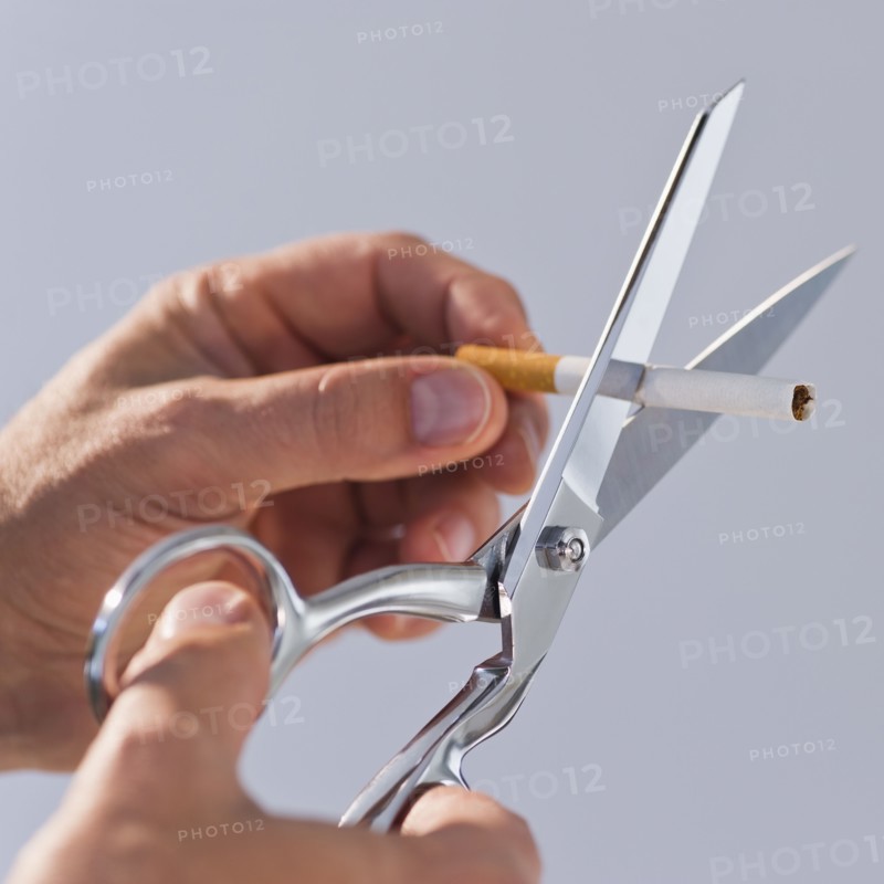 Hands cutting cigarette with scissors. Photo : Daniel Grill