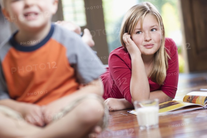 USA, Utah, Children (4-11) relaxing in home, girl reading book. Photo : Tim Pannell